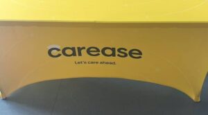 Yellow 180 gsm stretch table cover printed with a client logo on a 6 ft trestle table